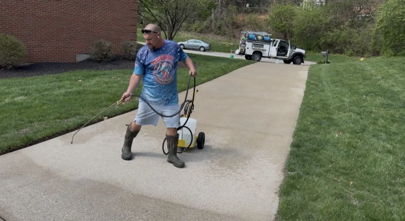 DJ of Liberty Power Wash applying concrete sealer to a driveway in Milford, OH