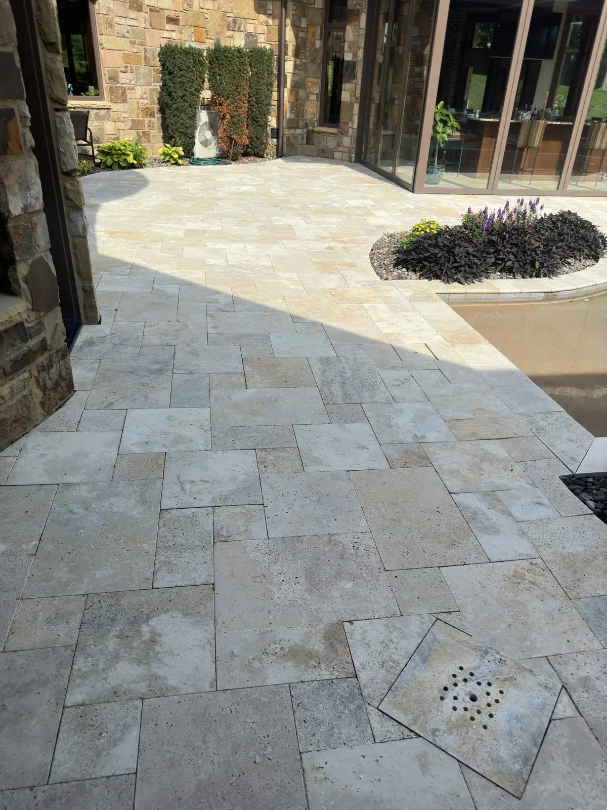 Travertine stone patio by the pool after professional cleaning in Burlington, KY