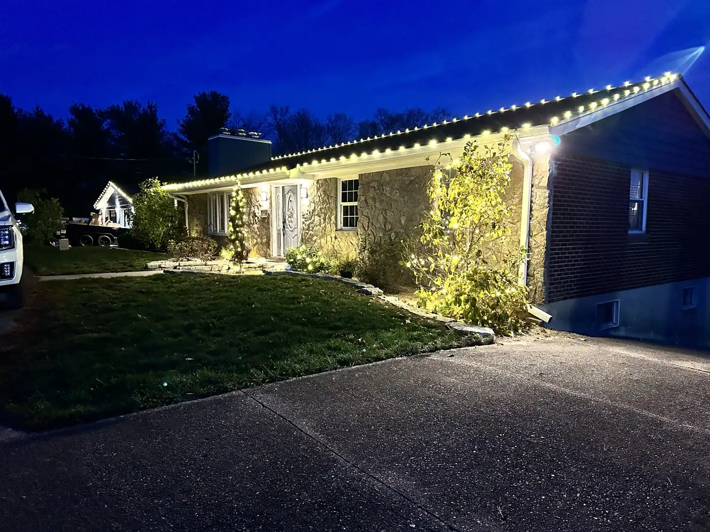 Christmas Light Installation in Hebron, KY Christmas roofline lights on a brick ranch home at dusk