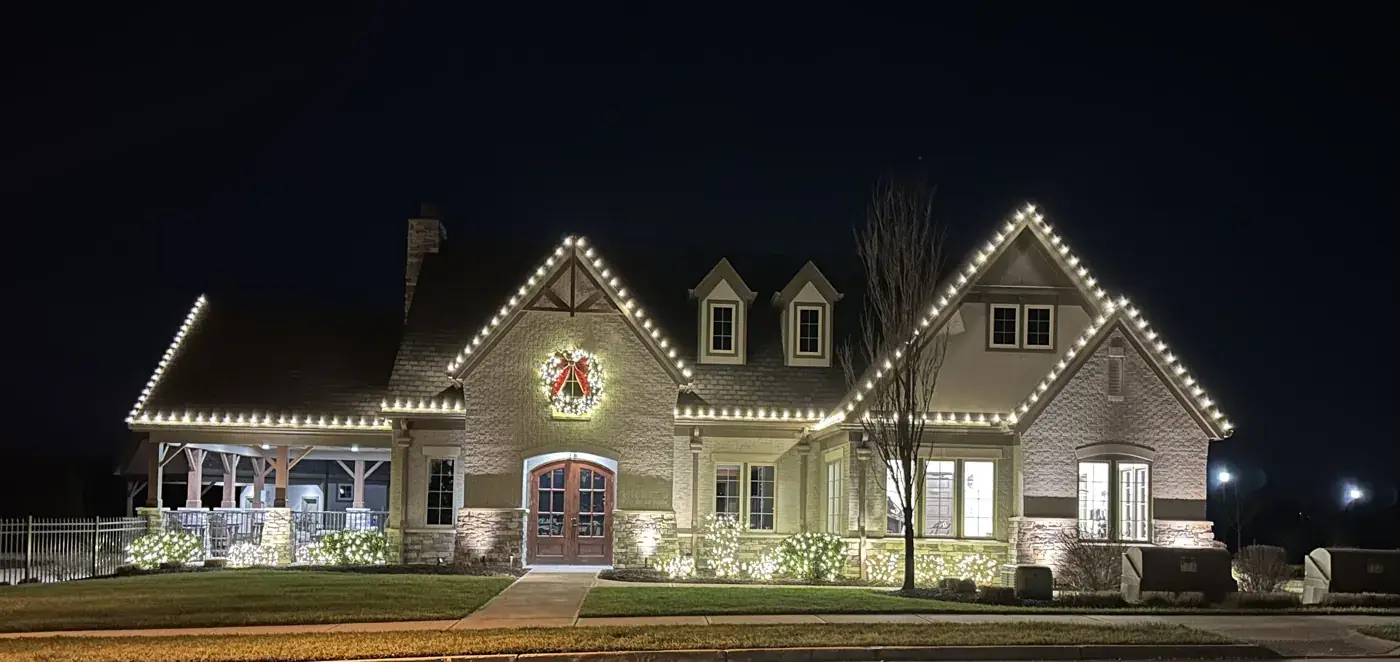 Christmas Light Installation in Loveland, OH Christmas roofline lights and a centered wreath on a farmhouse-style home in Loveland, OH