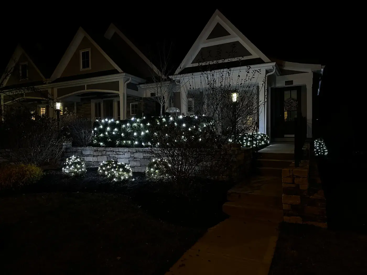 Christmas Light Installation in Loveland, OH Front landscaping bushes wrapped in cool white Christmas lights in Loveland, OH