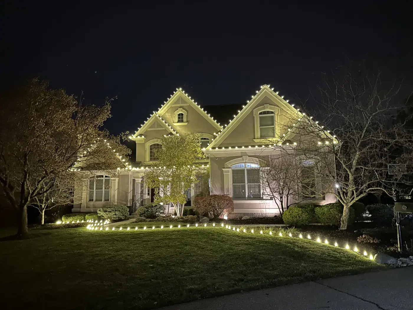 Christmas Light Installation in Miami Heights, OH Christmas roofline lights with a lit landscape bed border