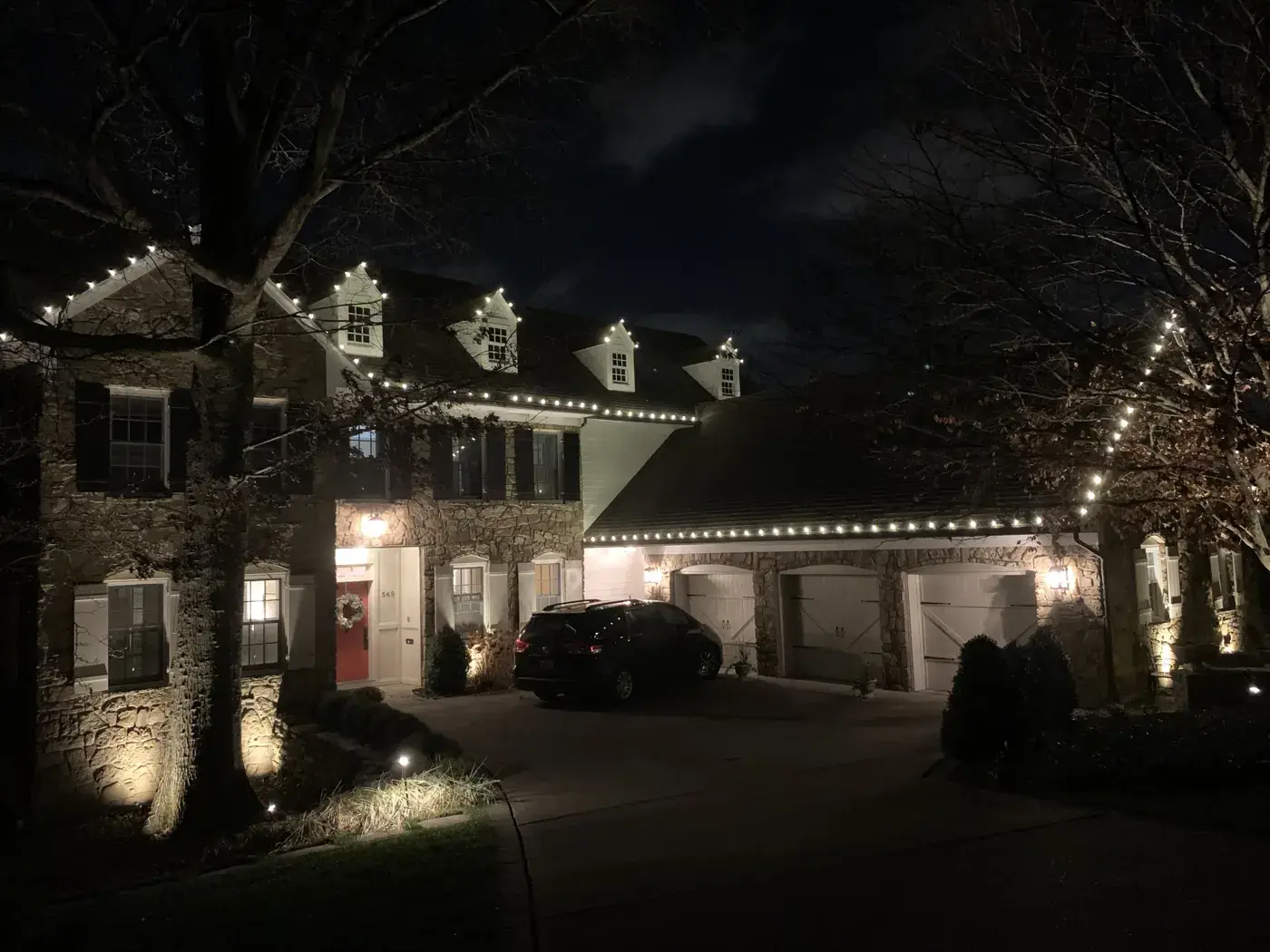 Christmas Light Installation in Edgewood, KY Christmas lights on a stone home with lit dormers and uplit trees