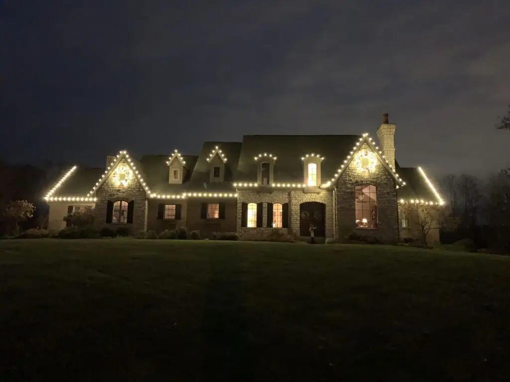 Christmas Lighting Warm white C9 Christmas lights on a stone home roofline in Cincinnati