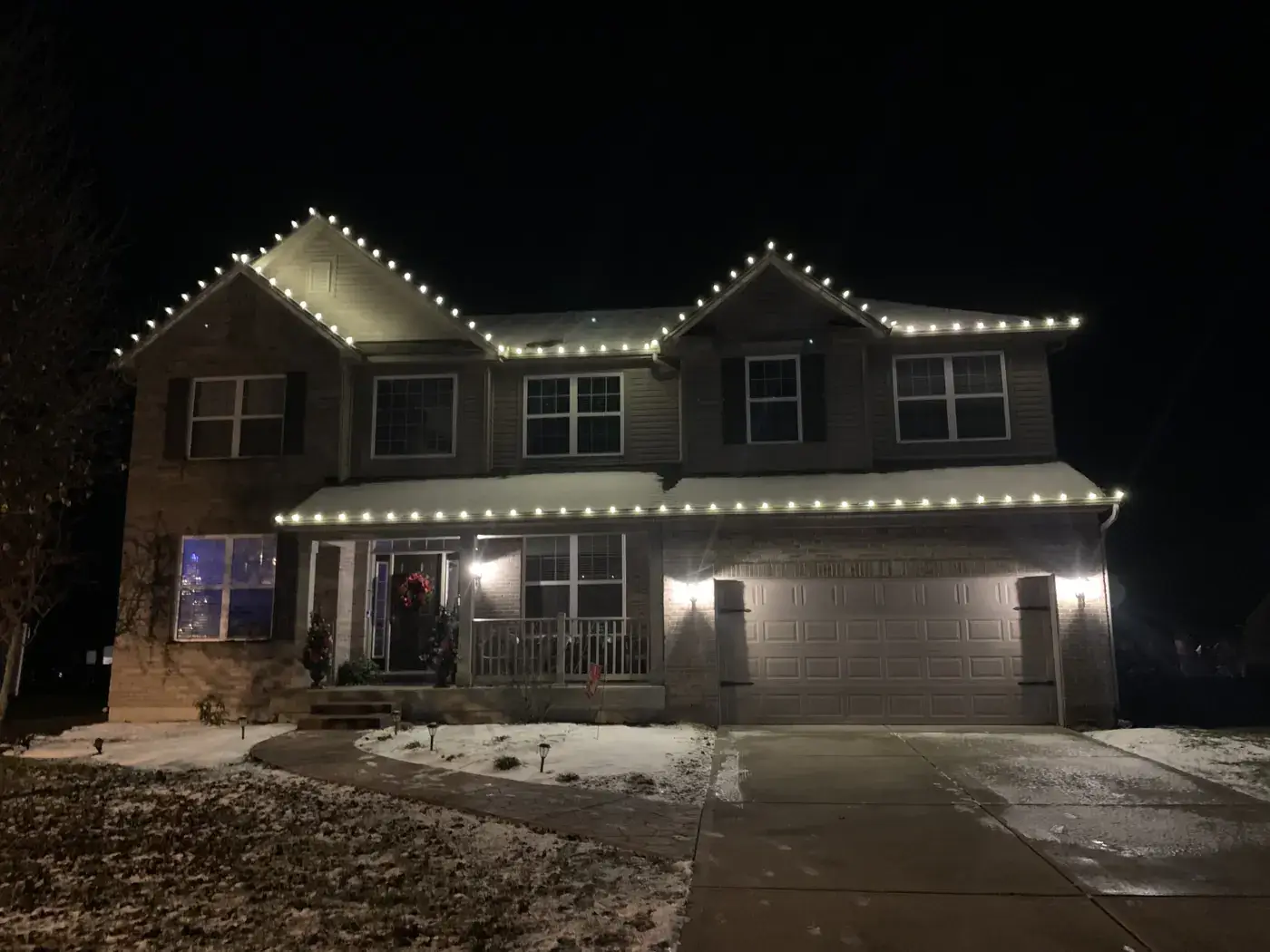 Christmas Light Installation in Liberty Township, OH Christmas roofline lights on a two-story home with snow on the ground